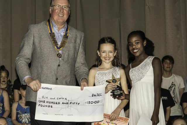 President of the Vale of Belvoir Rotary Club Adrian Cresswell presenting Ria and Safiya with Â£150 for finishing second PHOTO: Supplied