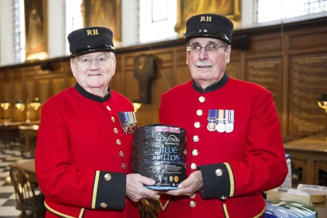 Two Chelsea Pensioners show off Stilton cheese donated by Long Clawson Dairy as part of the veterans' annual celebration of British cheesemakers EMN-171220-114404001