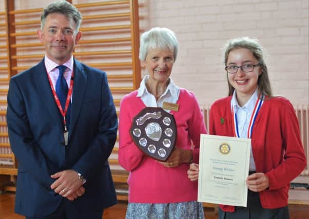 The overall champions of last year's Young Writer competition - Brownlow pupil Izabella Roberts receives the winners shield from Rotarian Maggie Saunders and head teacher Damien Turrell PHOTO: Supplied