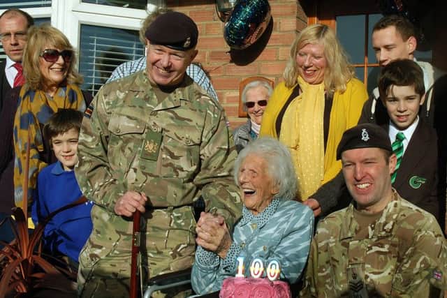CRSM Stuart Rowles and Staff Sergeant Ben Moore with Joan Hart and her family of daughters, grandchildren, and great-grandchildren at her special birthday celebration EMN-180129-103036001