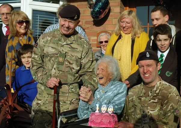 CRSM Stuart Rowles and Staff Sergeant Ben Moore with Joan Hart and her family of daughters, grandchildren, and great-grandchildren at her special birthday celebration EMN-180129-103036001