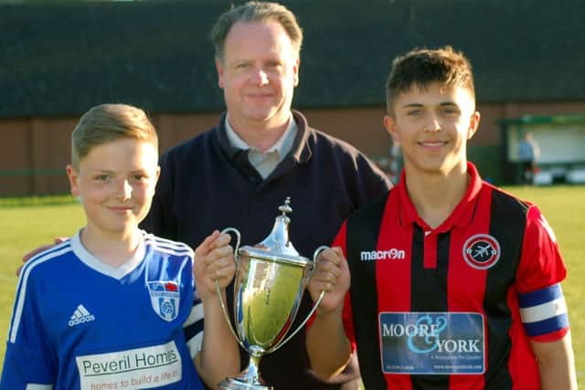 Secretary of Melton and District Charity Cup Committee Alan Digby with Sileby captain Luke Barratt on the left, and Ben Marshall from Barrow at last year's final EMN-180222-184748002