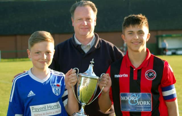 Secretary of Melton and District Charity Cup Committee Alan Digby with Sileby captain Luke Barratt on the left, and Ben Marshall from Barrow at last year's final EMN-180222-184748002