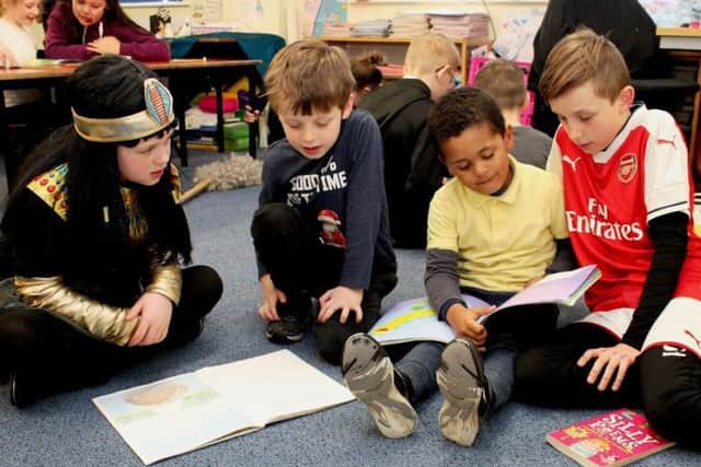 Year 5 at St Francis Catholic Primary School support younger children to read. Pictured left to right: Ruby Cropper (Y5), Isaac Wotton (Y1), Tobias Kumirayi (Y1) and Logon Srour (Y5) PHOTO: Supplied