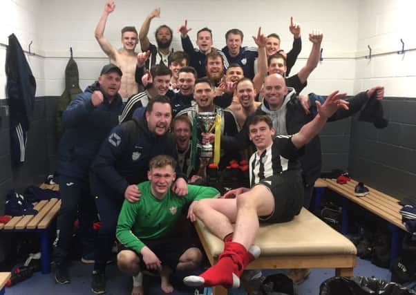 Wymeswold begin their dressing room celebrations with the cup EMN-180327-102757002