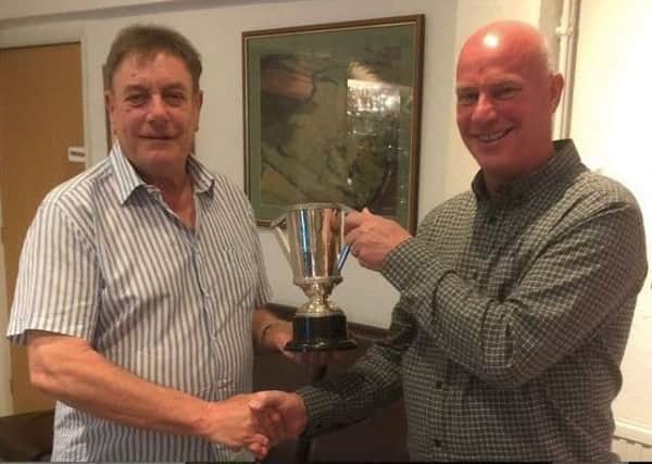 Melton Mowbray Golf Club captain Glenn Price (left) presents the Autumn Trophy to winner Steve Goddard. EMN-180416-120238002