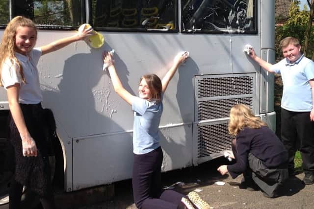 Year 6 pupils scrub the bus PHOTO: Supplied