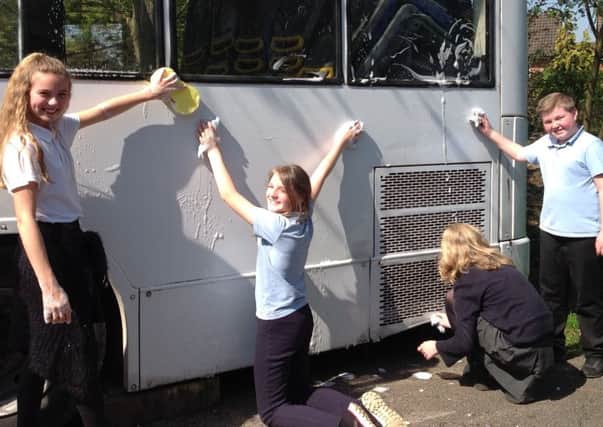 Year 6 pupils scrub the bus PHOTO: Supplied