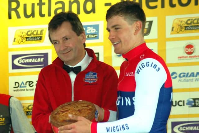 Race winner Cullaigh receives his giant pork pie from Stephen Hallam, of Dickinson and Morris, as first rider across the line to begin finishing circuit EMN-180424-125506002