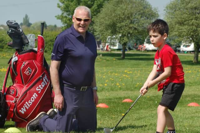 Seven-year-old Charlie Funnell gets some golfing tips from Melton Golf Club professional Tony Westwood PHOTO: Tim Williams