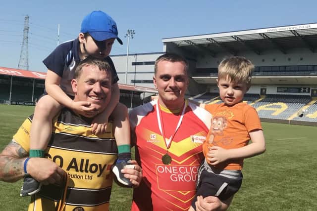 Melton RFC players James Marman (right) and Craig Simpson celebrate with their children after helping break the world record for the longest continuous rugby match EMN-180805-161521001