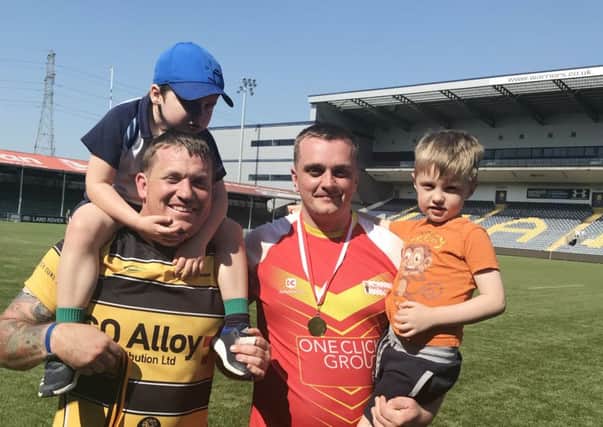 Melton RFC players James Marman (right) and Craig Simpson celebrate with their children after helping break the world record for the longest continuous rugby match EMN-180805-161521001