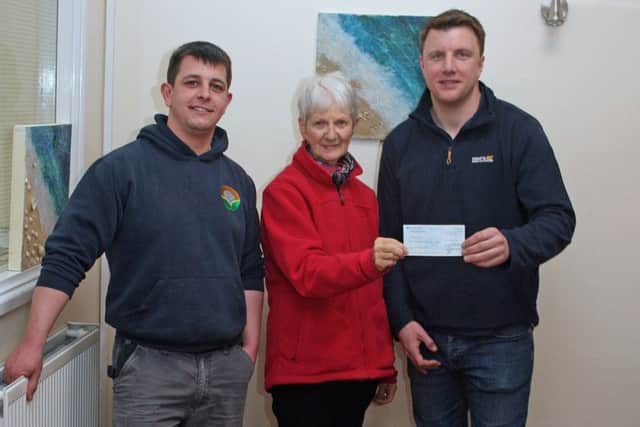 Rotarian Maggie Saunders presenting a cheque for £500 to Ian Bitmead (right), who is in charge of the workshop, and Tom Askew PHOTO: Supplied