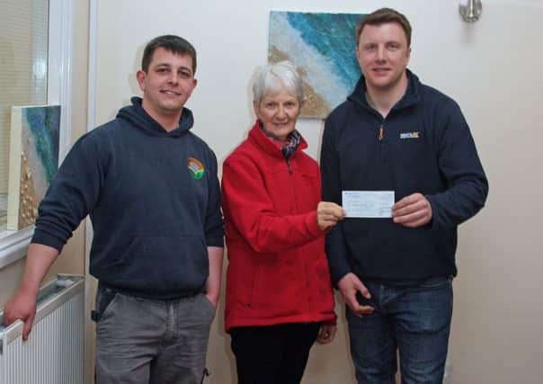 Rotarian Maggie Saunders presenting a cheque for Â£500 to Ian Bitmead (right), who is in charge of the workshop, and Tom Askew PHOTO: Supplied