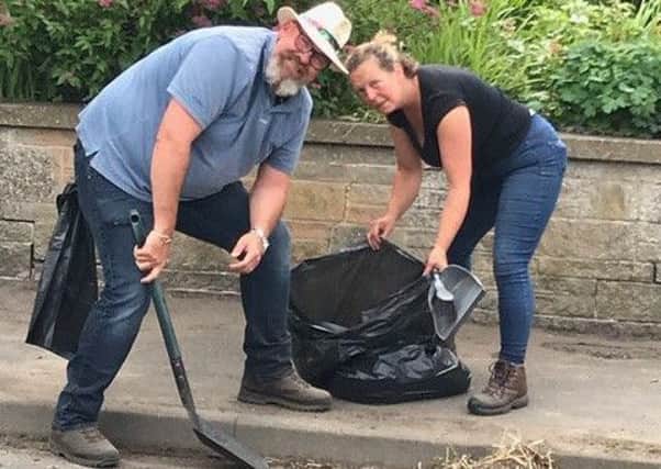 Rosalie and Andre Mould hard at work clearing the roadside gulley as part of the clean-up Rempstone campaign PHOTO: Supplied