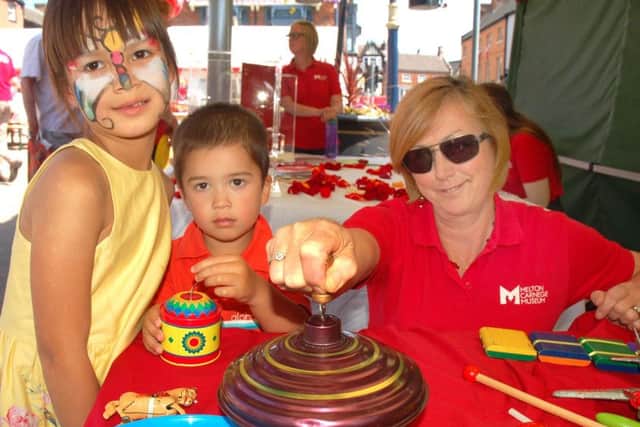 Maia and Jack Paige learn all about traditional childrens' toys with Heather Woodhouse from the Carnegie Museum at Paint The Town Red EMN-180625-125605001