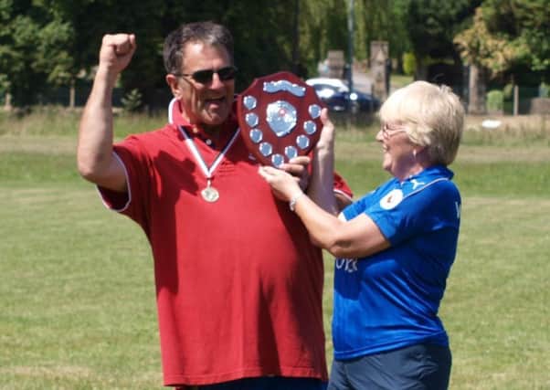 Kevin and Paula Wright lift the Knockout Cup. They set up Wrighty's XI in memory of their son Stephen EMN-180627-121935002