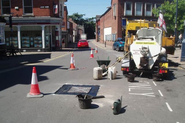 Workmen do preparatory work on manholes in Leicester Street prior to repairs being made to stop them rattling.
PHOTO JOHN ARTHUR EMN-180627-142301001