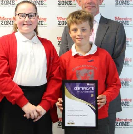 Brownlow Primary School head teacher Damien Turrell and two pupils receive their Beyond Bullying Award at a ceremony at Leicestershire County Council EMN-180407-131602001