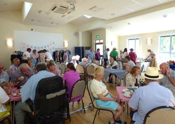 Fete-goers enjoy refreshments and stalls in the village hall PHOTO: Supplied