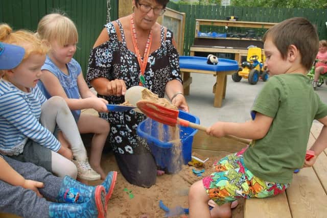 Children at the Oasis Family Centre enjoy an activity in the sandpit with staff member Bev Felstead EMN-180907-120311001