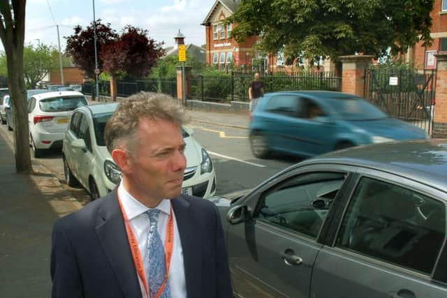 Damien Turrell, head teacher of Brownlow Primary School in Melton, surveys the busy scene outside at the end of Monday's school day EMN-180907-163415001
