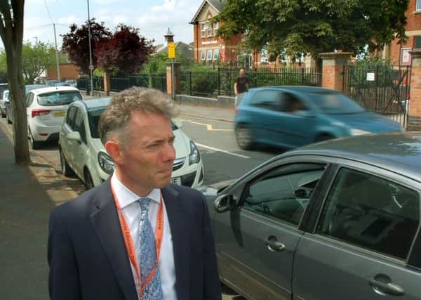 Damien Turrell, head teacher of Brownlow Primary School in Melton, surveys the busy scene outside at the end of Monday's school day EMN-180907-163415001