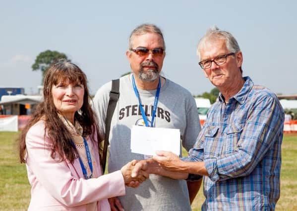 Christine Slomkowska, managing director at 103 The Eye, with executive director Patrick McCracken, receiving a cheque for Â£500 from Colin Fox at the Great Rempstone Steam and Country Show PHOTO: John Perring