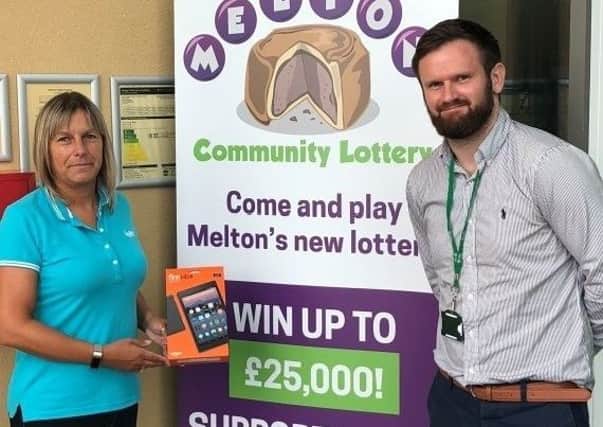 Sally-Anne Morgan receives her Melton Community Lottery prize of an Amazon Kindle Fire tablet from the borough council's leisure & culture client manager, Jake Betts EMN-180718-165126001