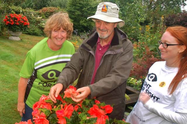 Hilary and Richard Lawrence admire a spectacular begonia with Rebecca Ingle PHOTO: Tim Williams