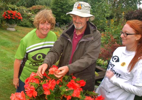 Hilary and Richard Lawrence admire a spectacular begonia with Rebecca Ingle PHOTO: Tim Williams