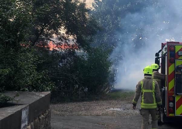 Firefighters pictured tackling a blaze at Waltham involving corn crops, agricultural machinery and a car EMN-180608-093108001