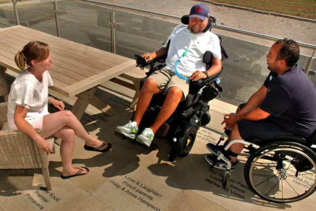 Matt Hampson and colleagues from the charity relax in the decking area which contains slabs with messages from sponsors and supporters of the Get Busy Living Centre EMN-180608-115248001