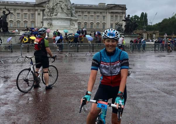 Theresa Coltman pauses for a photo with Buckingham Palace at a sodden Ride London EMN-180708-175438002