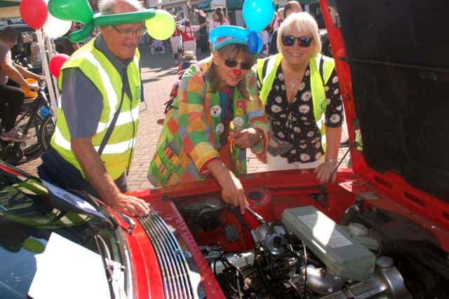 Rotarians Ian Neale and Julia Hinde get some mechanical advice from Hattie the Clown PHOTO: Tim Williams