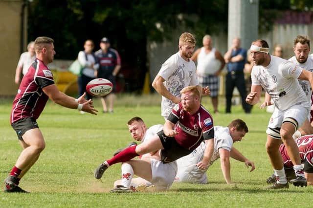 Duncan Lennox gets the ball away under pressure to skipper Leon Gormley EMN-180409-152953002