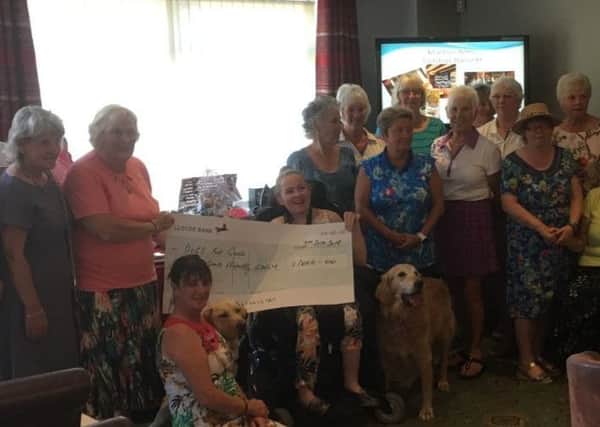 Sandie presents a cheque to Dogs For Good at her Lady Captains day EMN-180409-160746002