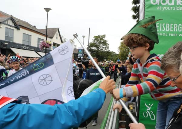 Chris Froome (bottom left) smiling at Sam as he prepares to wave his flag to start the Tour of Britain PHOTO: Supplied