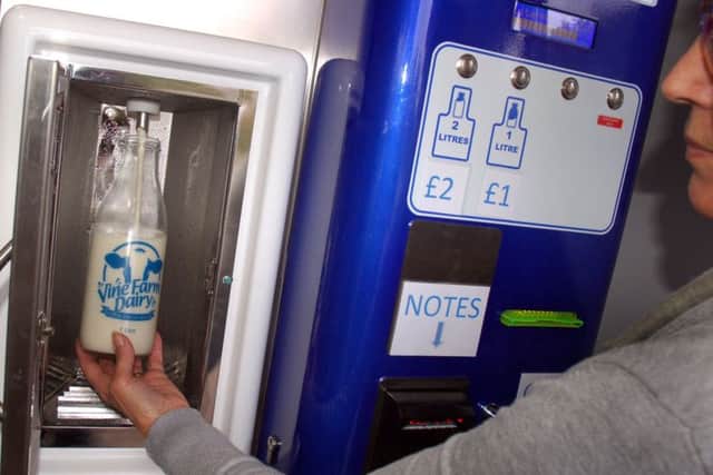 A customer uses the milk vending machine at Vine Farm, Great Dalby EMN-180919-095615001