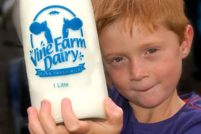 Oliver Mann with a fresh bottle of milk from his parents' vending machine at Vine Farm, Great Dalby EMN-180919-095626001