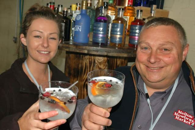Chloe King and market manager Tim Webster with the variety of gins on offer PHOTO: Tim Williams