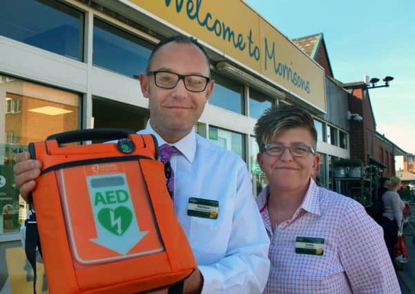 Matthew Griffiths, with Morrisons store manager Evette Ainley-Hall, holding the in-store defibrillator which he used to save a Melton customer's life EMN-180110-105102001