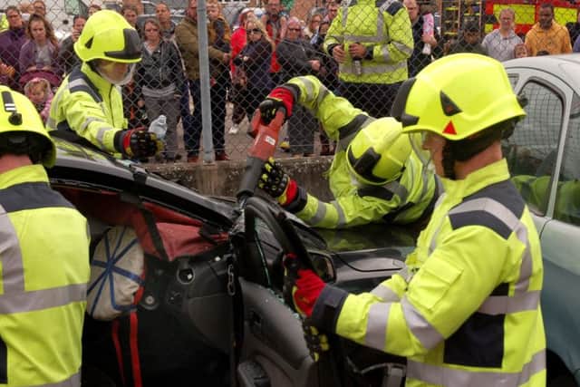 Firefighters carry out a demonstration on releasing a casualty from a traffic collision at a road safety awareness day at Melton Fire Station EMN-180110-105135001