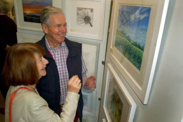 Keith Jones interested in one of Angela Shaw's pastel landscapes PHOTO: Tim Williams