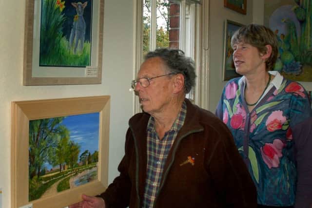 Rosemary Russell and David Cox with one of her oil landscapes PHOTO: Tim Williams