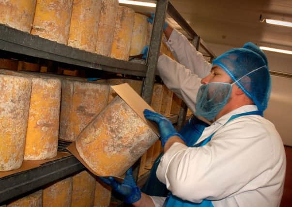 Cheeses are turned daily during the maturation stage at Long Clawson Dairy EMN-181218-180252001