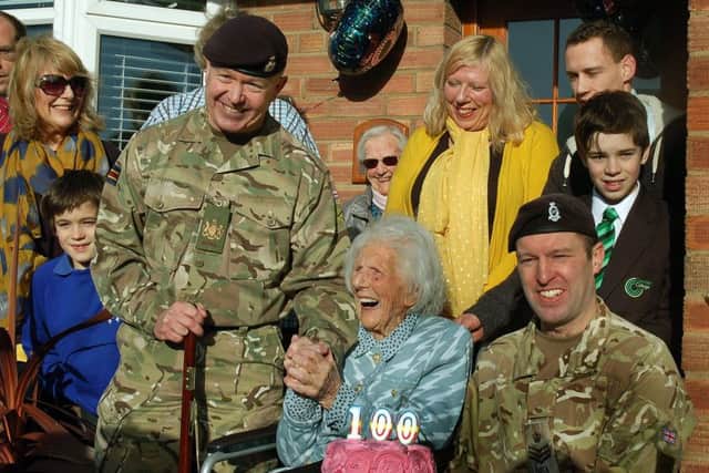 CRSM Stuart Rowles and Staff Sergeant Ben Moore with Joan Hart and her family of daughters, grandchildren, and great-grandchildren at her special birthday celebration EMN-181231-145931001
