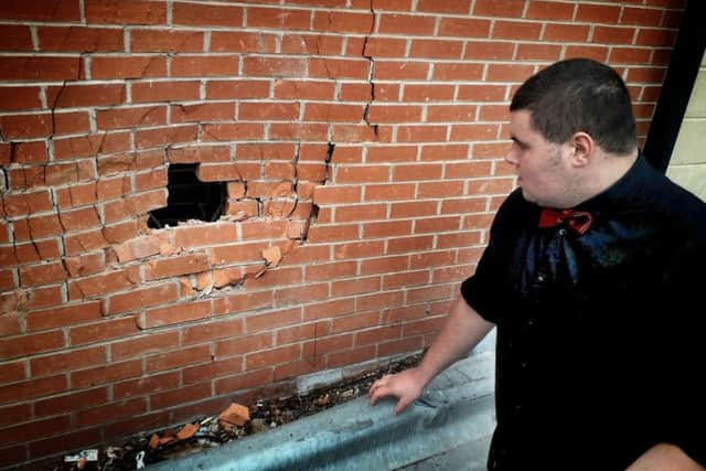 Staff member Isaac Thompson inspects the damage caused to a wall of The Kettleby Cross pub by a car crashing into it EMN-190401-163033001