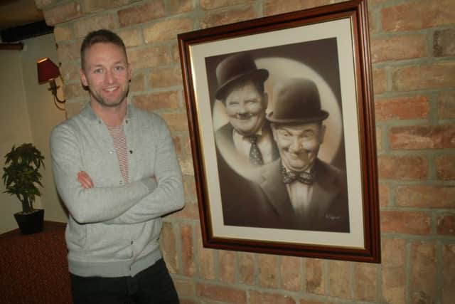 Landlord Callum McIver with a photo of Laurel and Hardy at The Bull Inn, at Bottesford EMN-190116-091624001