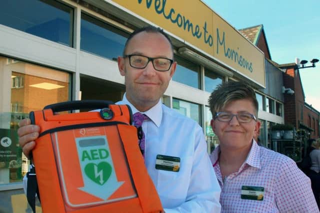 Matthew Griffiths, with Morrisons store manager Evette Ainley-Hall, holding the in-store defibrillator which he used to save a Melton customer's life EMN-190118-143357001